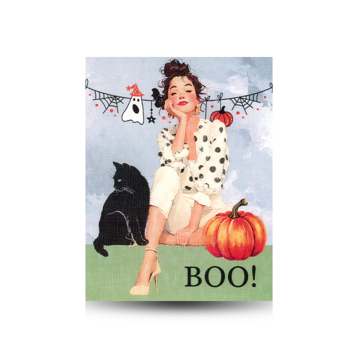 This card features a modern woman sitting on the ground with a pumpkin and black cat beside her. There is halloween bunting behind her and the sky is grey. She is wearing heels, light cropped pants and a white and black polka dot blouse.