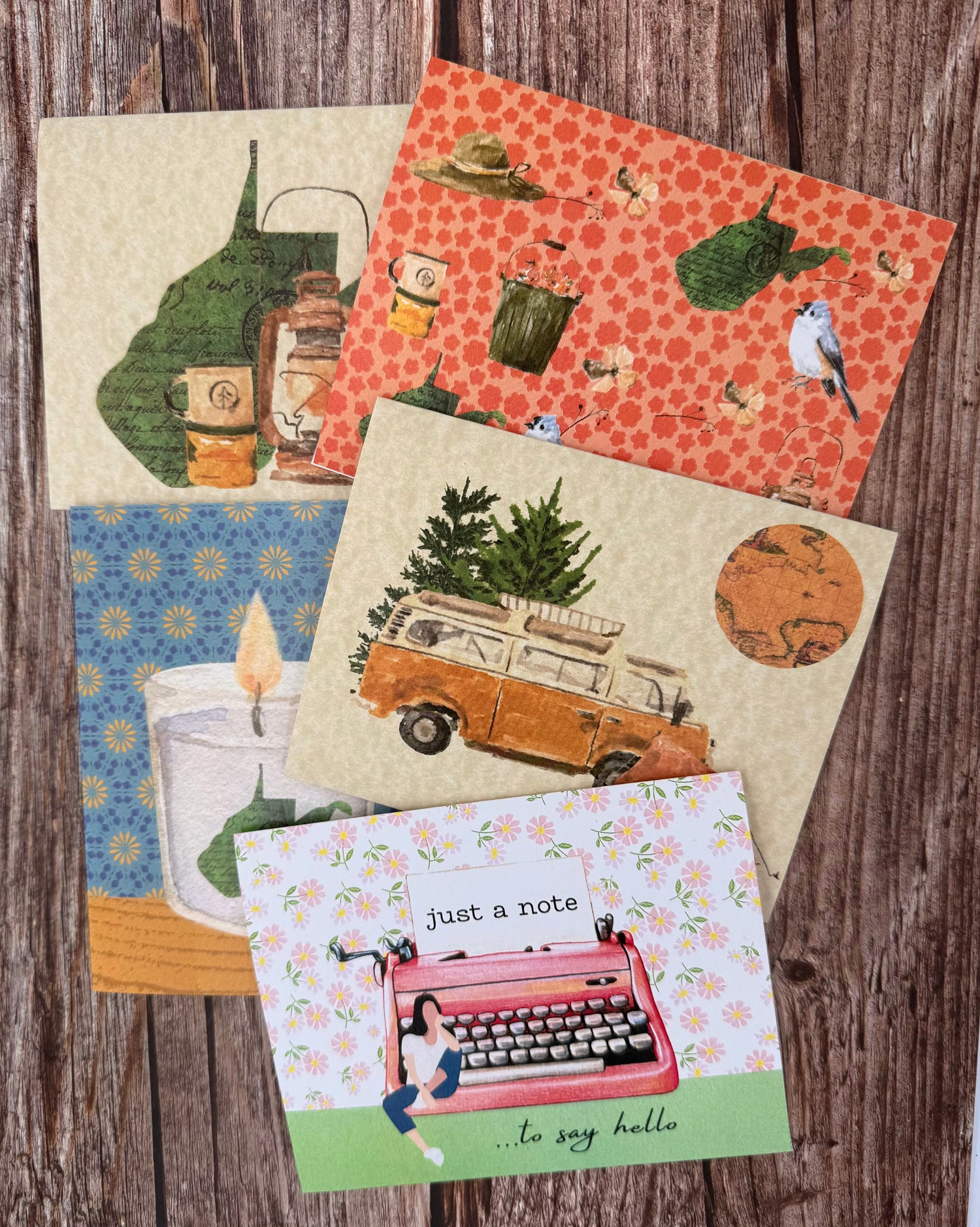 INN RETROspect's original notcards displayed on a wooden table. These note cards are playful and feature mixed textures, imagery, and colors. Some depicting West Virginia and others showcasing strong women characters. 