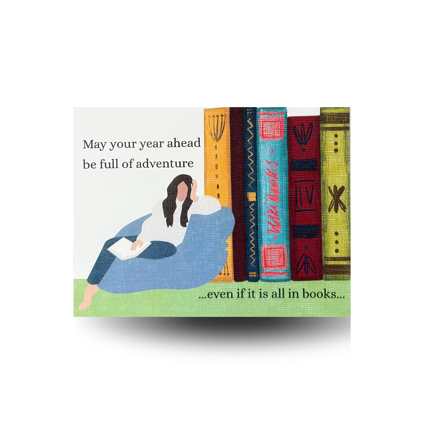 This birthday card features a modern woman lounging on a blue beanbag chair while reading.  There is an oversized stack of books beside her.  The greeting "May your year ahead be full of advance...even if it is all in books..." is written to the side and at the bottom of the scene. 