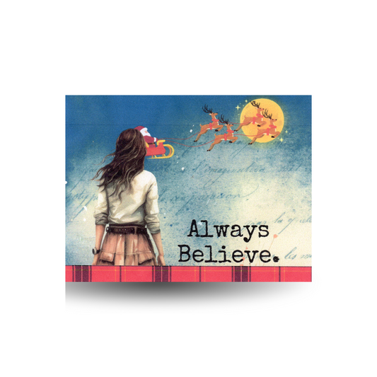 This Christmas card features a modern woman from behind.  She is wearing a brown skirt and cream long sleeve top and has long brown hair.  She is looking at the sky and Santa and his reindeer are flying in the sky in front of the moon.  The message "Always Believe" is on the right bottom side of the card.  The very bottom of the card is a red plaid.