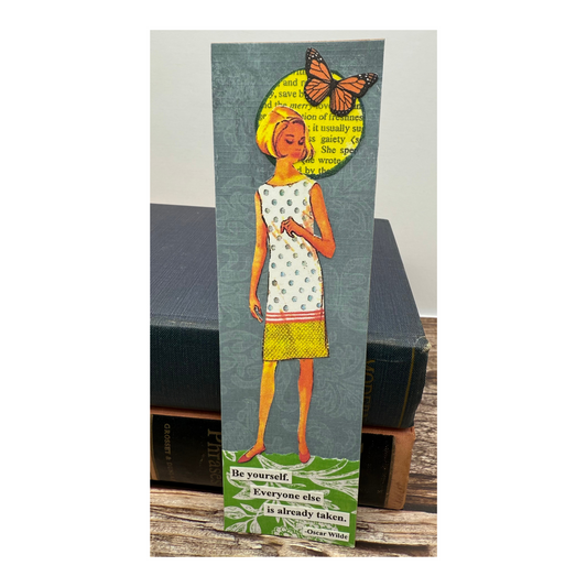 This is an originally collaged bookmark made of paper, featuring a blond girl in sleeveless dress standing on the quote by Oscar Wilde "Be yourself.  Everyone else is already taken."  There is a yellow word sun and butterfly by the girl's head.