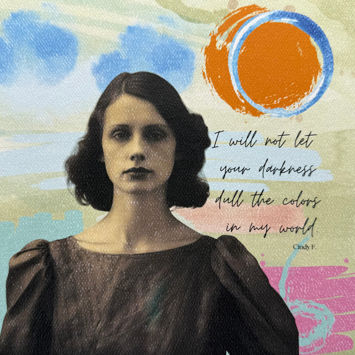 This art print features an abstract background with faded greens, pops of pink, blue clouds, and an orange sun with a blue ring around it.  Featured in front of this abstract scene is a vintage-style sepia photo of a woman with brown curly mid-length hair dress  in a brown dress, with a confident and stern look on her face.  The original quote by Cindy F. "I will not let your darkness dull the colors in my world" is written in cursive font to the right of the lady 