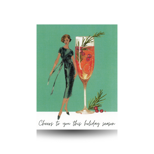 This card features a vintage woman in a green dress standing beside an oversized glass of champagne, adorned with Christmas greenery and berries.  There are also berries and pine at the base of the glass.  The background is green and the base is white, with the greeting: "Cheers to you this holiday season" written in script font across the bottom of the card