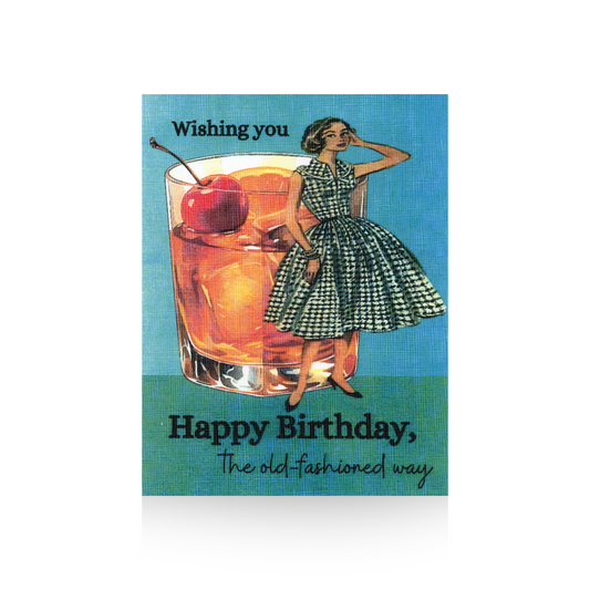 This birthday card features an oversized old-fashioned cocktail with an orange and cherry in it.  To the right of the cocktail is a vintage illustrated lady in a black and white checked sleeveless dress.  The background is blue and the base is green.  The freeing "Wishing you Happy Birthday, the old-fashioned way" is written on the top and base of the card
