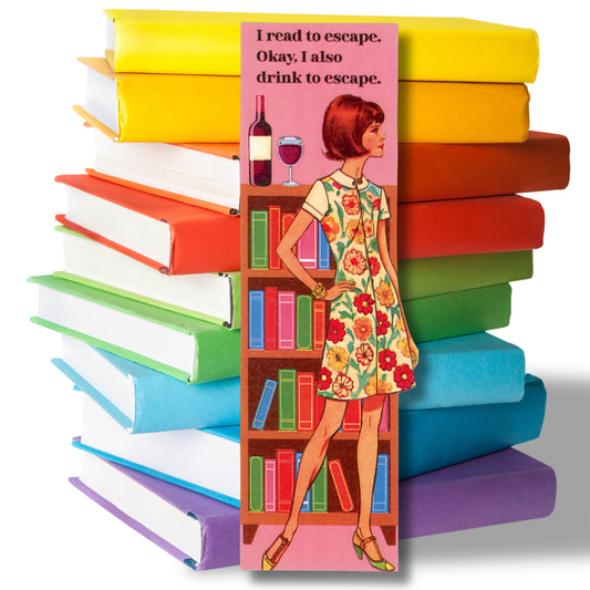 this photo shows a stack of bright-colored books with a bookmark standing in front featuring a vintage lady in a flowered dress standing in front of a bookcase with a bottle of red wine on top of the bookcase with the message "I read to escape.  Okay, I also drink to escape."
