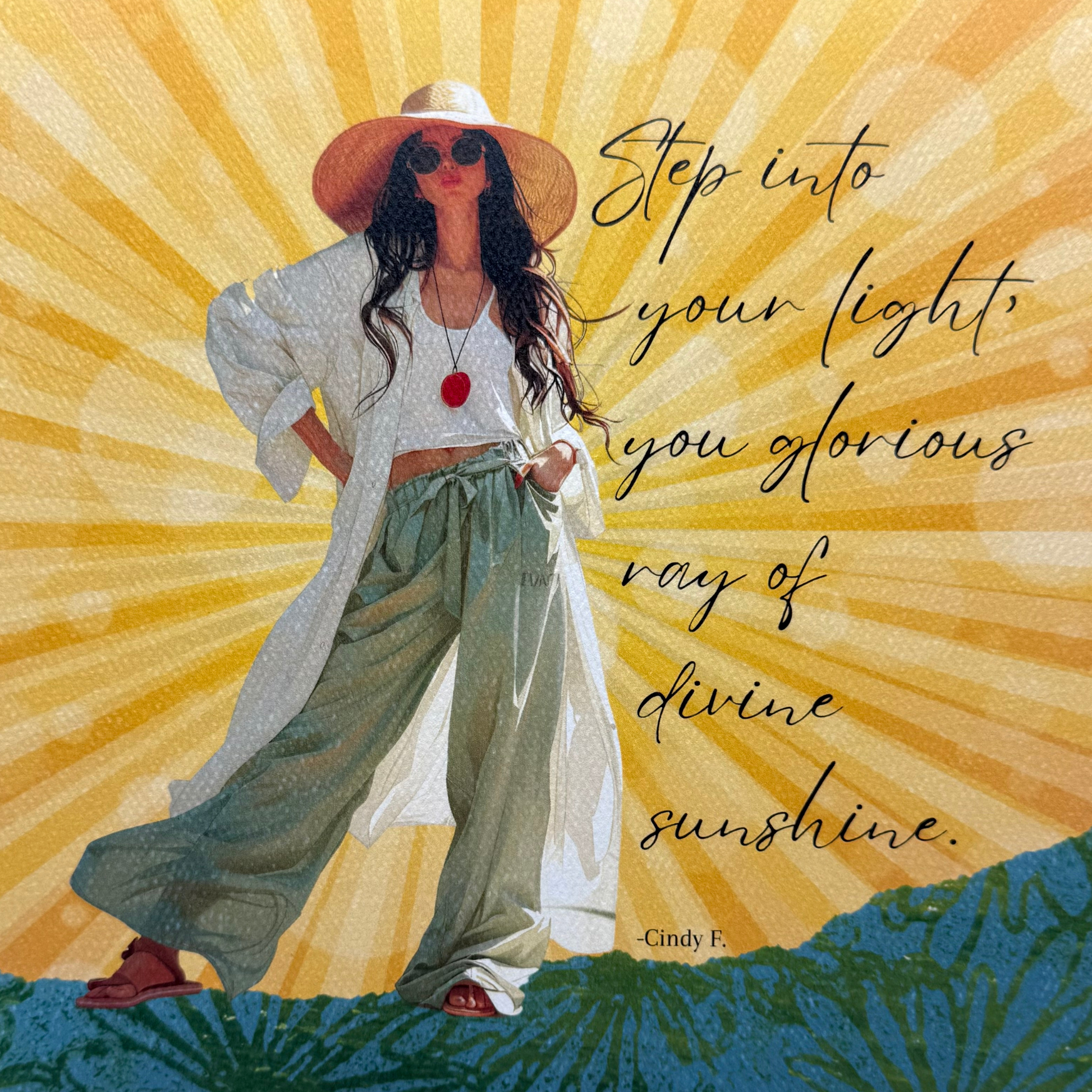 This art print features the original saying by Cindy F. "Step into your light, you glorious ray of divine sunshine."  The art print features a modern young woman with long brown hair, wearing green wide-legged pants, sandals, a long white shirt and a short white tank top, wearing a hat with a red disk necklace.  The background is a yellow sunburst and she is standing on a green print hill.  The quote is written in black cursive to the right of the girl 