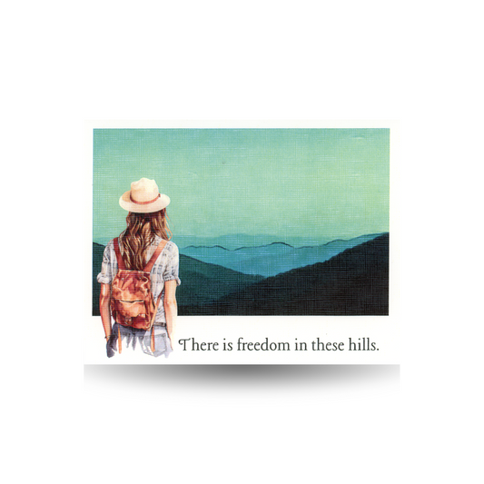 This card features a women wearing a plaid short-sleeved shirt and grey jeans carrying a backpack and hat looking at mountains with text 'There is freedom in these hills' appearing below the scene