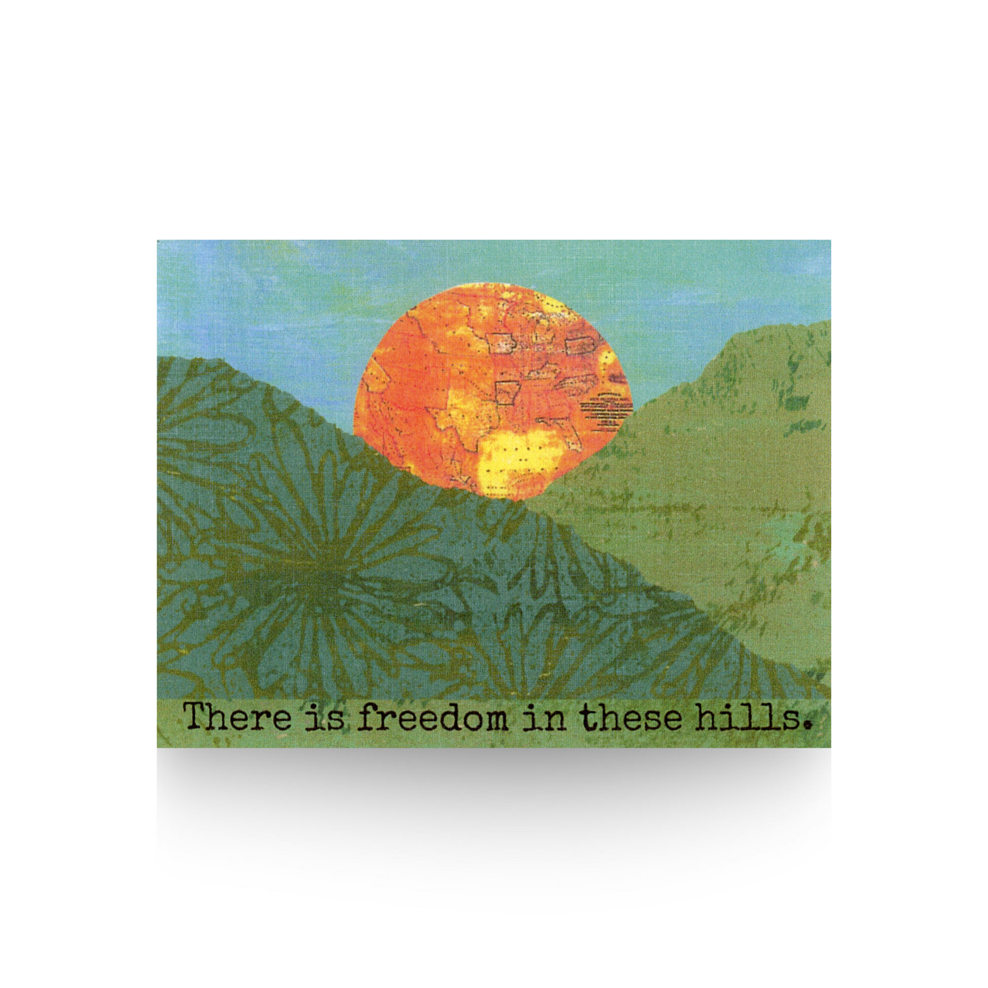 "There is freedom in these hills" greeting card features a collaged hill scene made from printed papers and a hand-painted blue sky.  A large orange sun that is a vintage map is rising up between the two hills.  The message "There is freedom in these hills" is at the base of the card