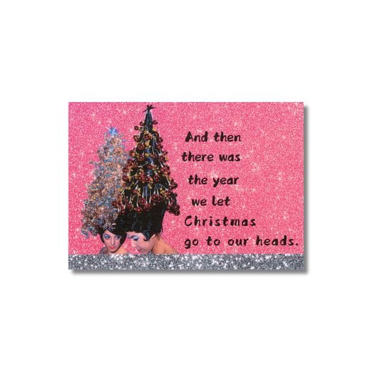 Card with vintage women with Christmas trees on heads and humorous text on a pink sparkly background.  The message is written to the right side of the ladies:  "And then there was the year we let Christmas go to our heads." 