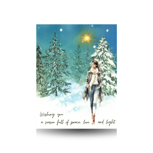 Winter scene with a woman walking in the snow, surrounded by trees and a starry sky.  She is wearing jeans, boots, a cream sweater, and a tan long coat