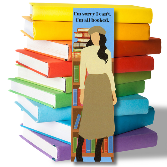 photo features a stack of colorful books with a bookmark in front.  On the bookmark is a woman standing in front of a bookcase with the message "I'm sorry I can't.  I'm all booked."